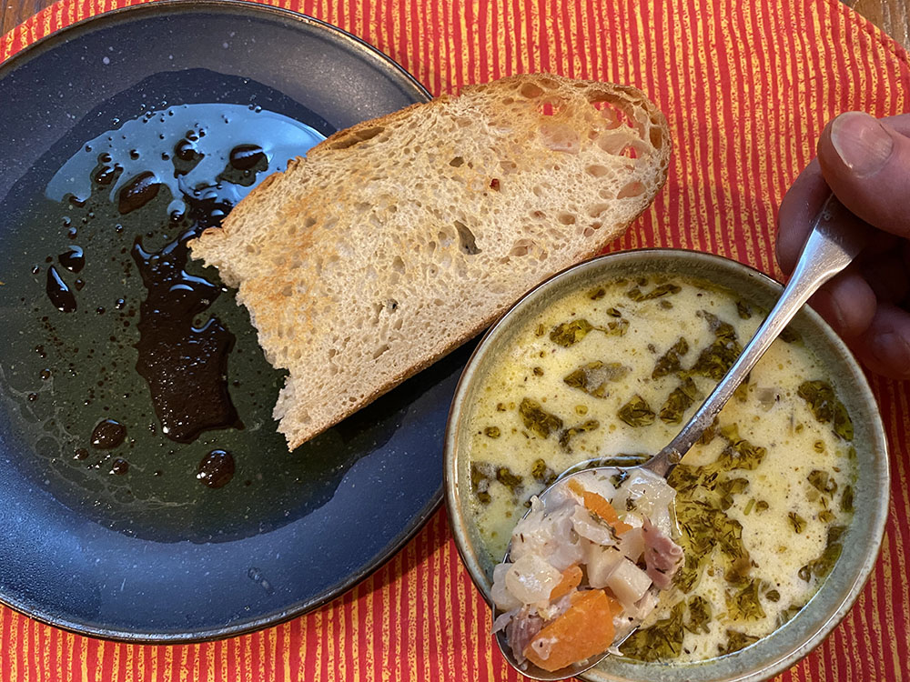 A bowl of creamy whitefish soup paired with crispy toasted bread.